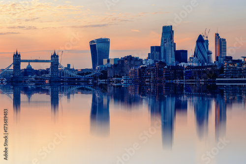 Cityscape of London at sunset with reflection from river Thames photo