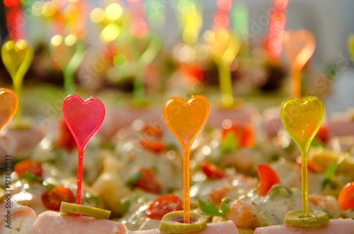 catering with plastic colorful heart shape sticks on small sandwiches photo