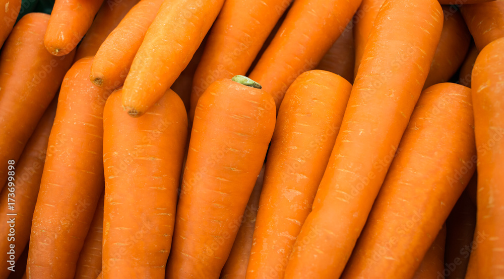 Close up a fresh carrots for background. The Carrot is root vegetable, usually orange in colour, though purple, yellow cultivars exist. Close up a fresh carrots for background. The Carrot is root vegetable, usually orange in colour, though purple, yellow cultivars exist.
