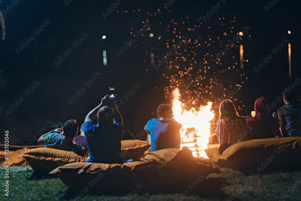 Group of people near camp fire with campfire song and campfire meals  playing campfire games and