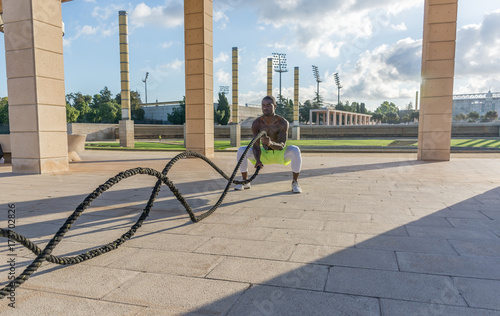 male muscular training with battle ropes and training mask photo
