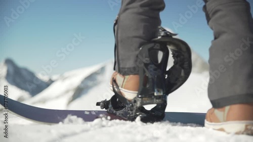 Snowboarder strapping in