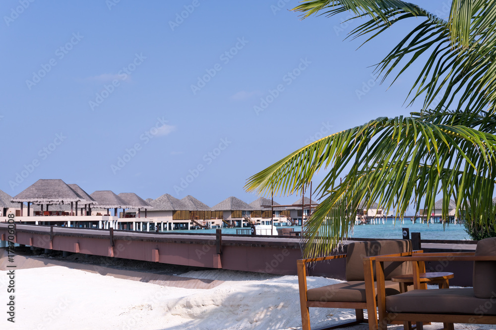 Obraz premium Tropical travel destination with pristine beach and water bungalows