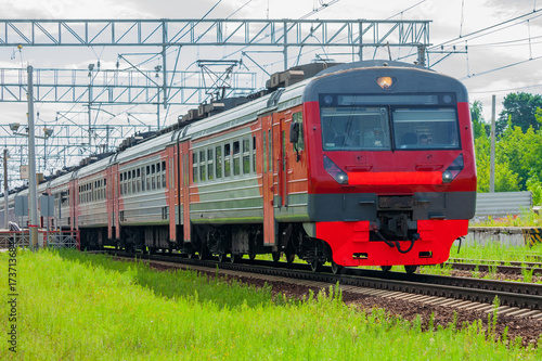 Train moves against the background of green trees © Mikhail