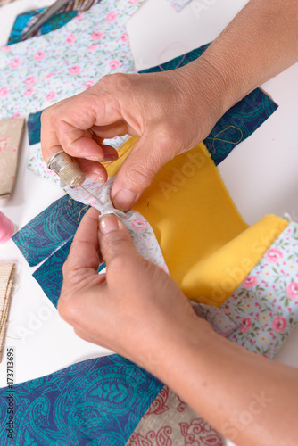 woman hands sewing for finish a quilt.