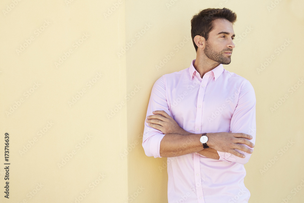 Guy in pink shirt on yellow wall, looking away Guy in pink shirt on yellow wall, looking away