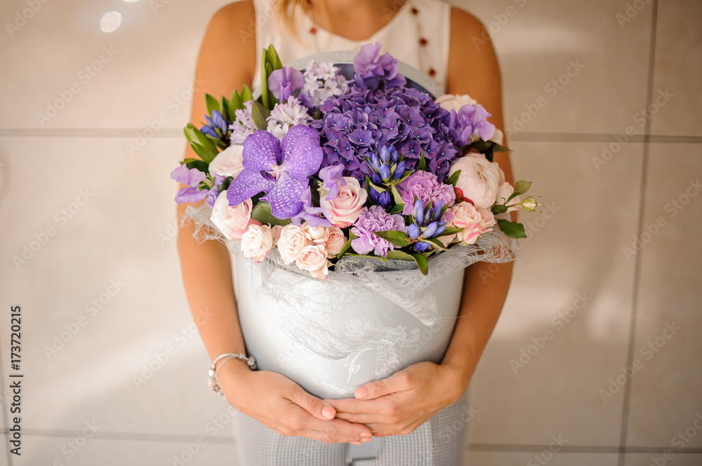 Woman hands with a beautiful purple composition of flowers