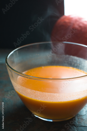 Pumpkin soup in a glass bowl side view