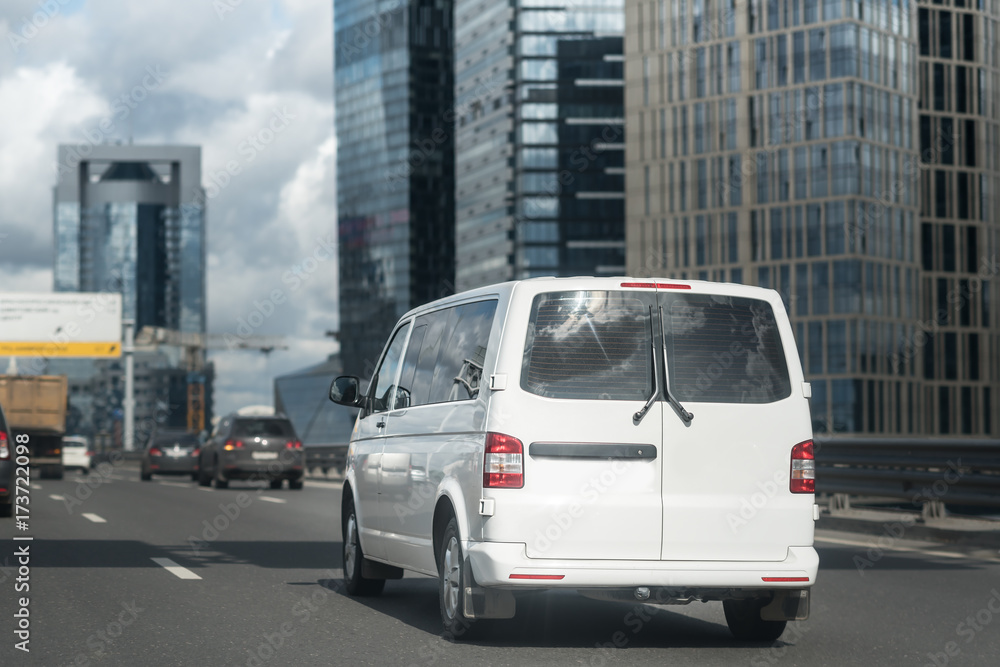 white minibus goes on the city street white minibus goes on the city street