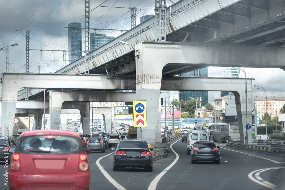 Architecture of highway construction in daytime. Road with cars under the big overpass. Moscow