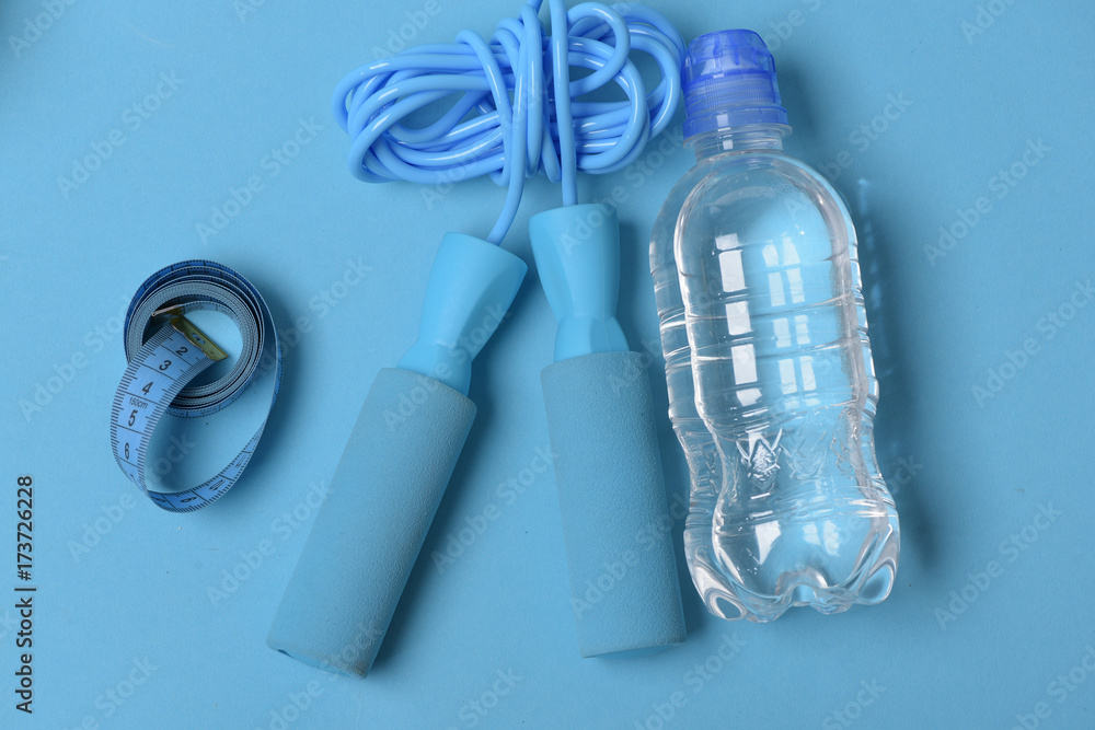 Naklejka premium Skipping rope in cyan color on blue background, top view.