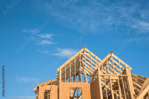 фотографія Close-up of gables roof on stick built home under construction and blue sky in Humble, Texas, USA