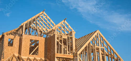 Quadro su tela Close-up of gables roof on stick built home under construction and blue sky in Humble, Texas, USA