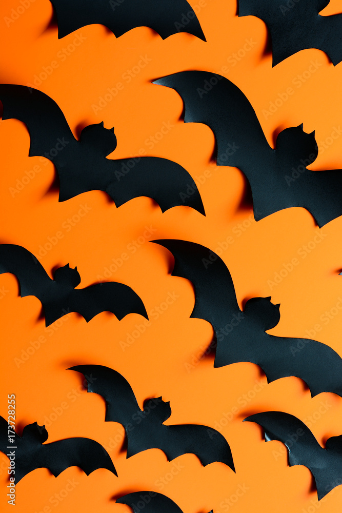 A flock of paper bats on the orange wall
