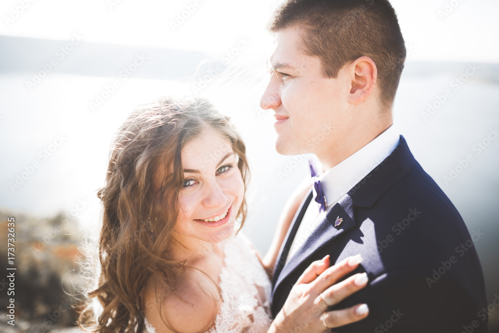 Happy and romantic scene of just married young wedding couple posing on beautiful beach Happy and romantic scene of just married young wedding couple posing on beautiful beach