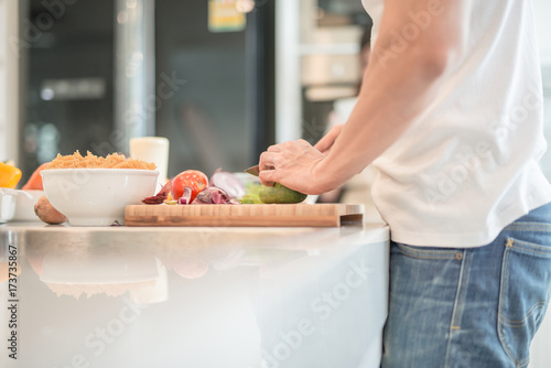 Closeup portrait of a male hands cutting vegetable at the kitchen