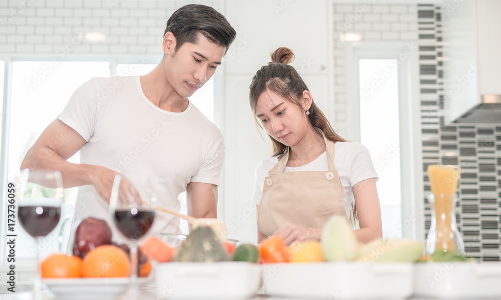 young happy couple cooking together in the kitchen at home. young happy couple cooking together in the kitchen at home.
