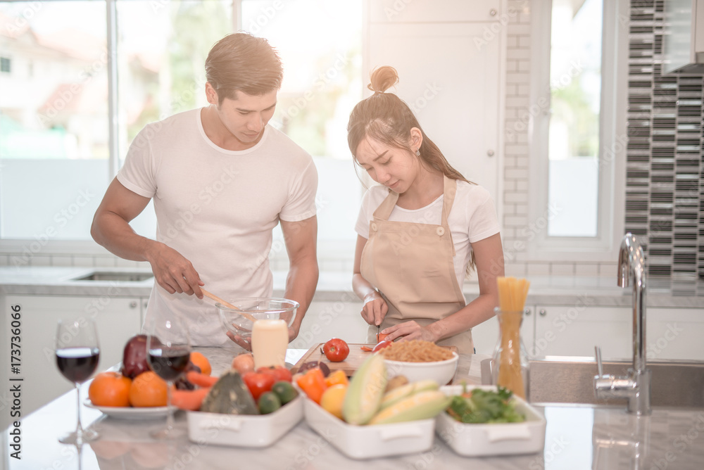 young happy couple cooking together in the kitchen at home. young happy couple cooking together in the kitchen at home.