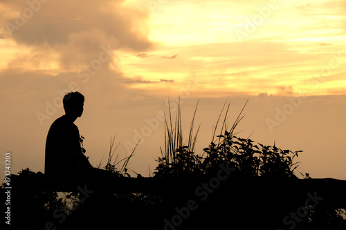Silhouette Man sitting watch the evening sky at sunset