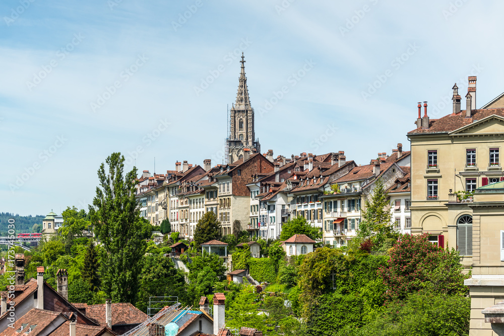 Picturesque panorama of the old town. The tall steeple of the Bern Minster that is rising high above the city buildings of Bern, Switzerland