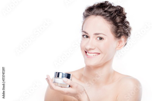 Young woman holding a face cream.
