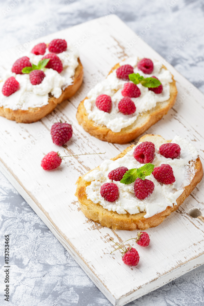 Breakfast slice of bread with Ricotta cheese served with raspberries Breakfast slice of bread with Ricotta cheese served with raspberries