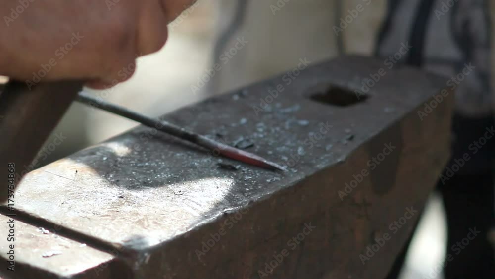 Blacksmith is hammering a red-hot piece of iron Blacksmith is hammering a red-hot piece of iron