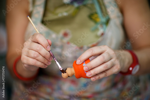 The hands of a woman artist at work in a craft workshop for the production of souvenirs