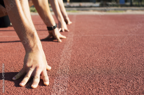 Close up mans and woman's hands on running track. Hands on a starting track.
