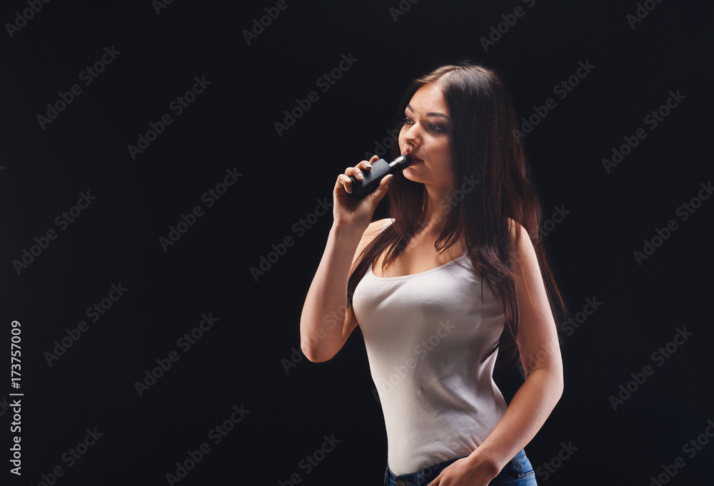 Young woman vaping e-cigarette on black Young woman vaping e-cigarette on black