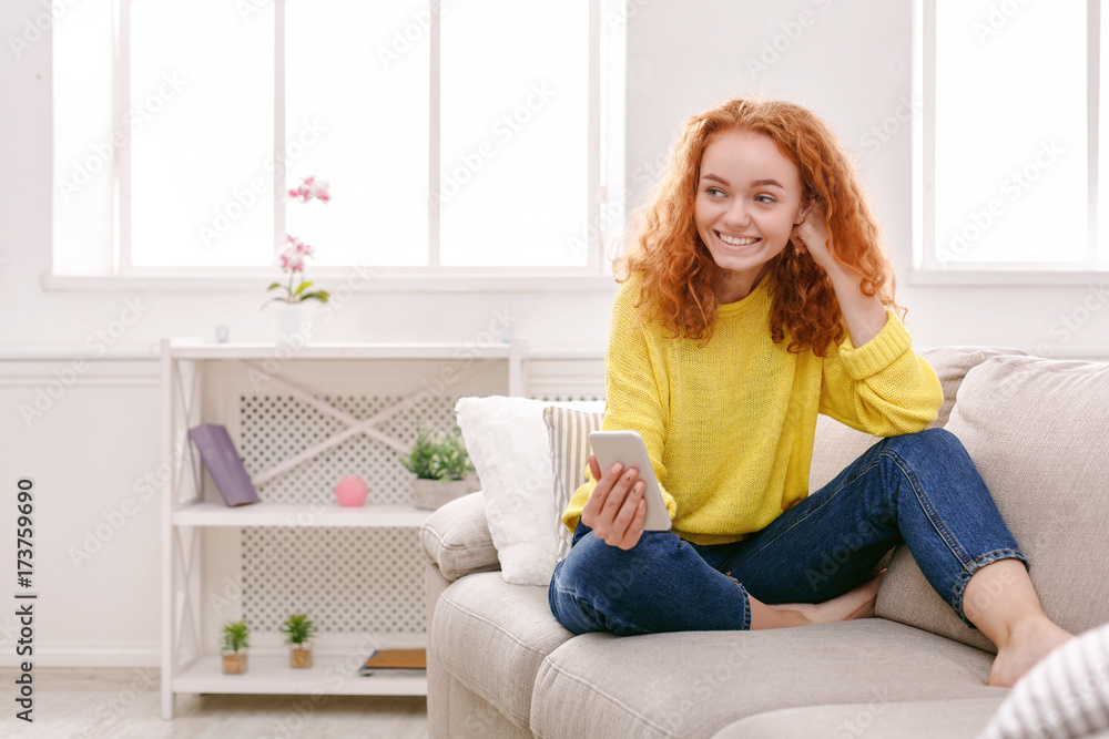 Smiling girl at home chatting online on smartphone Smiling girl at home chatting online on smartphone