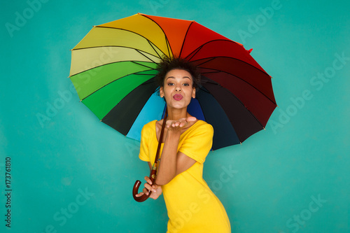 Happy girl with colorful umbrella at studio background