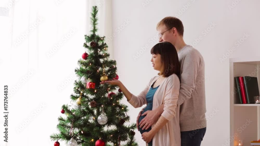 happy couple decorating christmas tree at home happy couple decorating christmas tree at home
