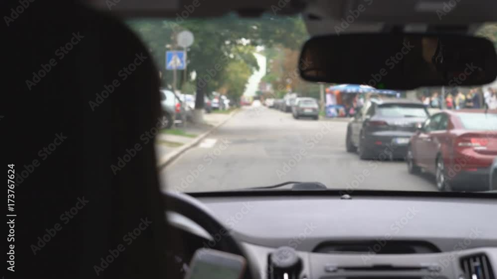attractive girl driving a car. Peeps messages on the mobile phone while driving. a woman does not face the way when creating dangerous emergencies. Shooting from the rear seat seat. 4 k attractive girl driving a car. Peeps messages on the mobile phone while driving. a woman does not face the way when creating dangerous emergencies. Shooting from the rear seat seat. 4 k