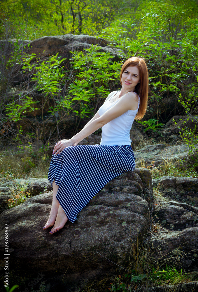 Beautiful young smiling woman with long red hair, wearing long