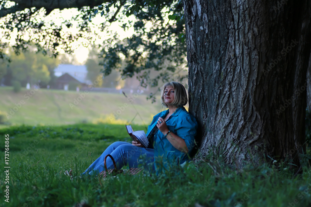 woman in the park tree reading book woman in the park tree reading book