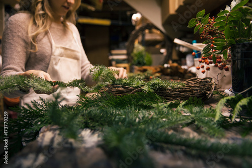 Woman's hands making a holiday wreath in work shop. photo