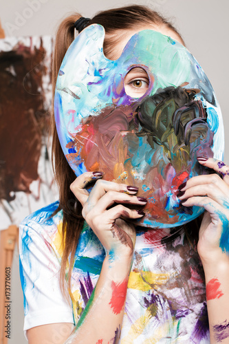  woman artistholds  palette with paints in front of face