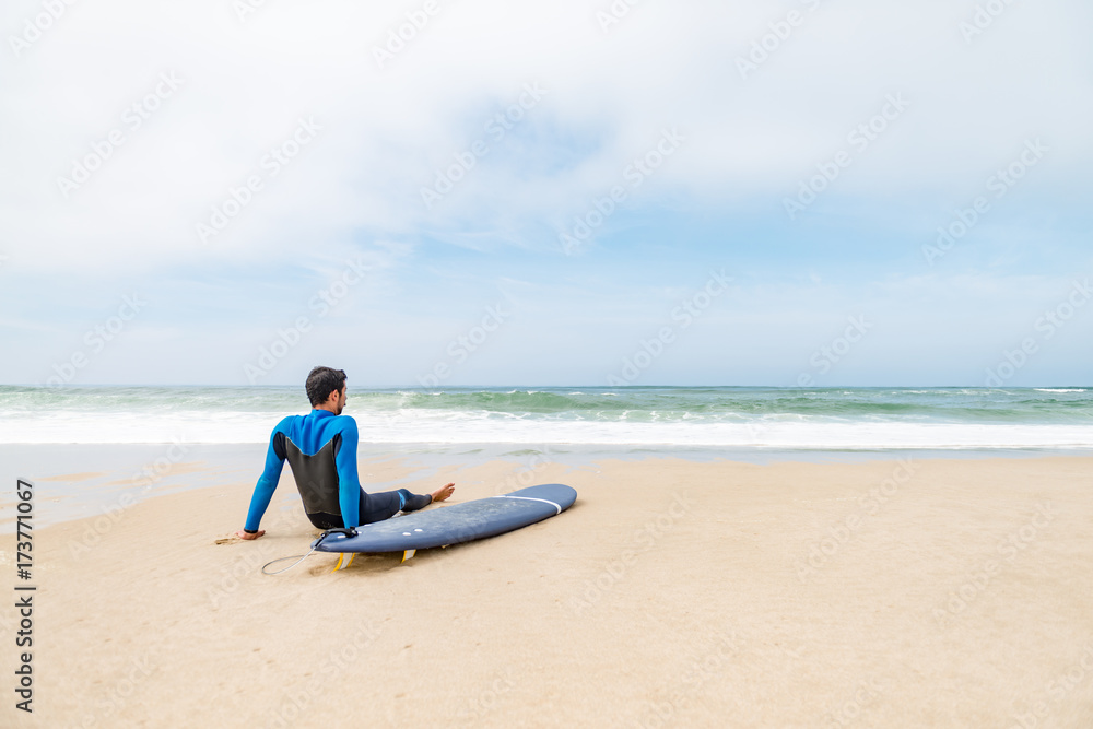 Young male surfer wearing wetsuit