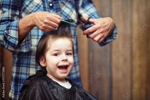 A little boy is trimmed in the hairdresser's