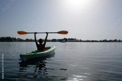 Boy in life jacket on green kayak