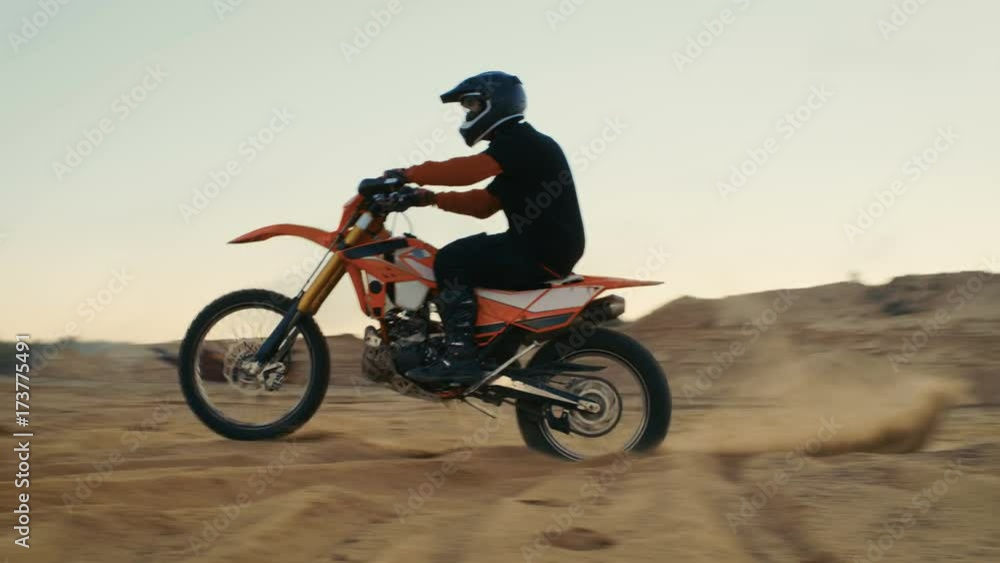 Professional Motocross Biker Drives His FMX Motorcycle of the Dune on the Off-Road Track. Shot on RED EPIC-W 8K Helium Cinema Camera. Professional Motocross Biker Drives His FMX Motorcycle of the Dune on the Off-Road Track. Shot on RED EPIC-W 8K Helium Cinema Camera.