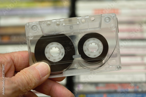 Hand holding cassette tape made of clear plastic photo