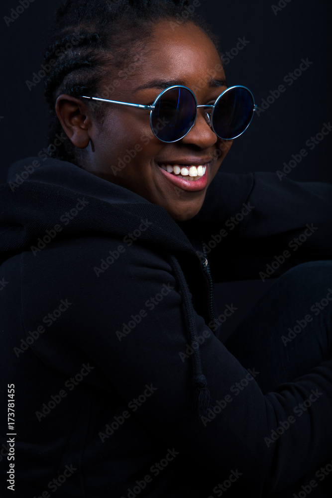 Obraz premium Woman Wearing Sunglasses While Smiling Over Black Background