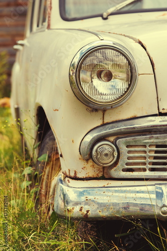 The old rusted machine. Front view where there is a spotlight with a grille and a bumper