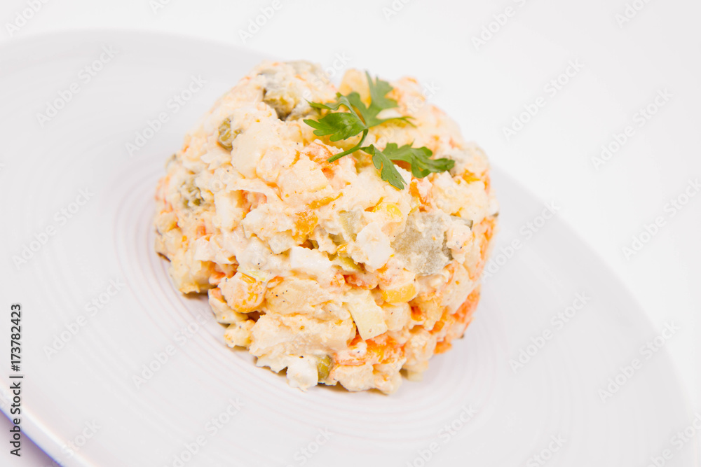 Vegetable salad (potato, carrot, corn, pea, egg, leek) with mayonnaise on a white background Vegetable salad (potato, carrot, corn, pea, egg, leek) with mayonnaise on a white background