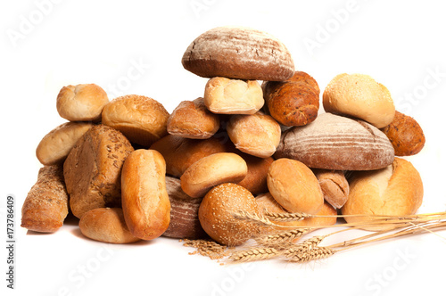 assortment of baked bread with wheat on white background 