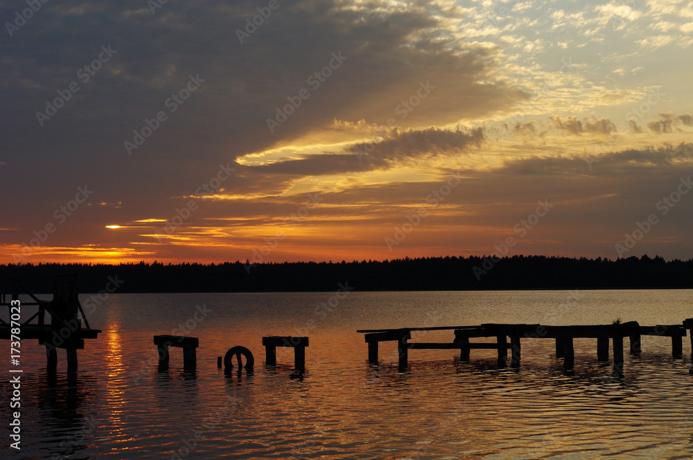 Sunset over the old fishing pier at the lake in Poland.