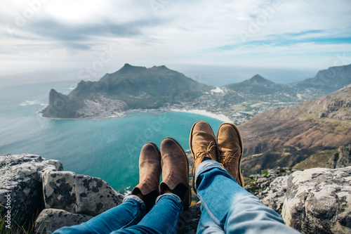 leather shoes and jeans of a relaxed hiking couple sitting at a mountain top photo