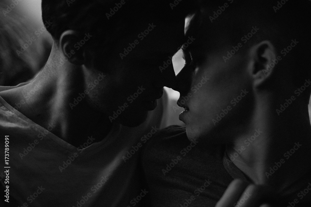 Young gay couple about to kiss in bedroom Young gay couple about to kiss in bedroom